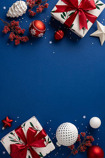 istock A vertical bright blue flat lay features wrapped gifts with red ribbons, red and white ornaments, berries, pinecones, a star, and a white textured ball, capturing Christmas and New Year celebration 2236996112