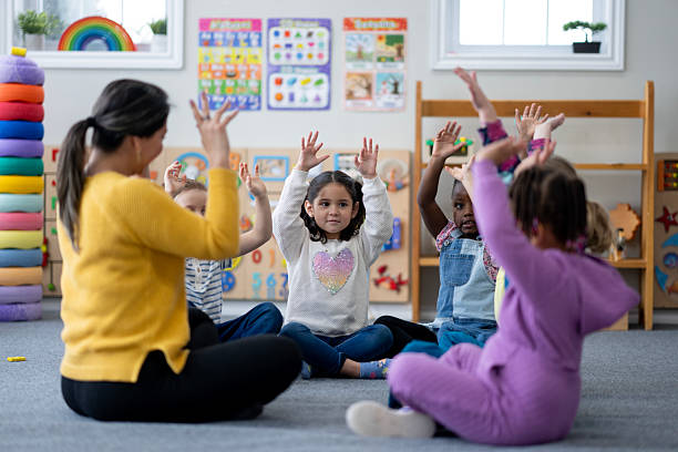 istock Teacher Leads Circle Time With Diverse Preschoolers Raising Hands In Class During Morning Activity 2236996696