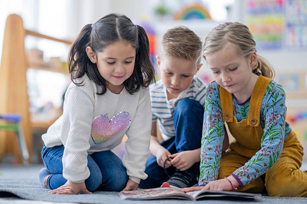 istock Three Children Reading Together in Classroom Corner, Learning, Friendship, and Concentration 2236996764