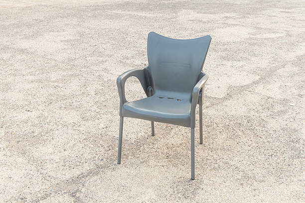 A Plastic black chair on the gray background