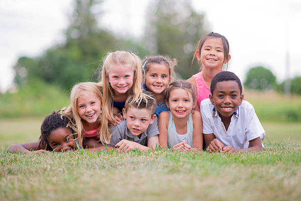 istock Group Of Diverse Kids Lying On Grass Outdoors, Smiling And Having Fun Together 2236998677
