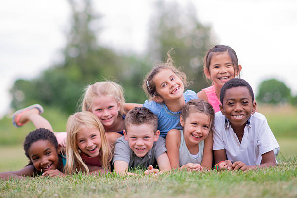 istock Diverse Group Of Kids Laughing And Playing Outdoors On Grass In A Park 2236998678