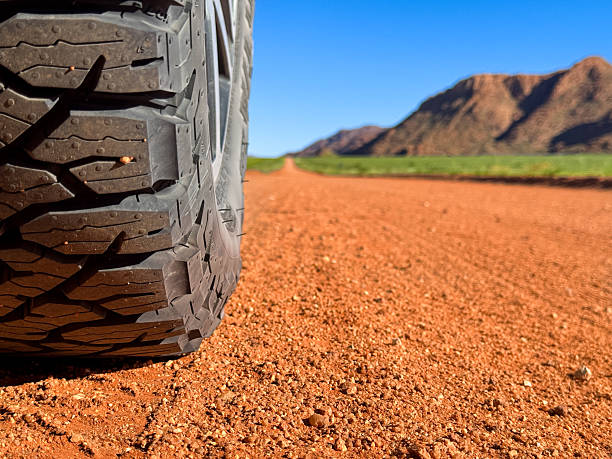 vehicle driving on dirt road with dust in air