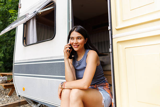 istock Young woman talking phone while sit in camper 2237001418