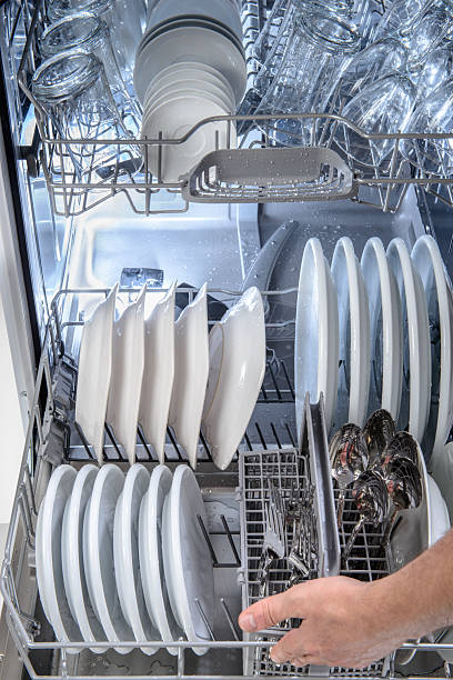 istock Hand loading plates and cutlery into a clean dishwasher 2237004750