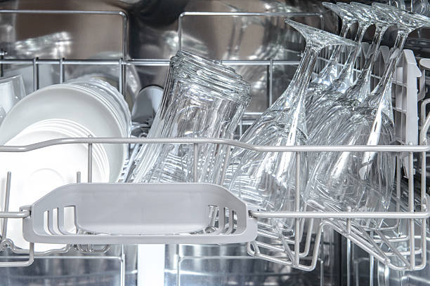Stainless steel interior of a modern dishwasher with sparkling clean dishes and glassware