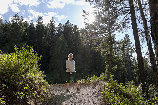 istock Mature woman hikes pathway in forest 2237010331