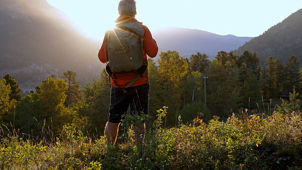 istock Mature man relaxes in mountain meadow at sunrise 2237010415