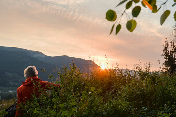 istock Mature man relaxes in mountain meadow at sunrise 2237010435