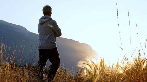 istock Mature man relaxes in mountain meadow at sunrise 2237010474