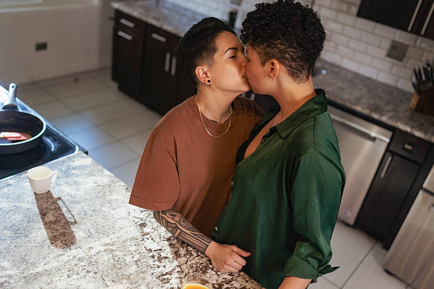 istock Lesbian Couple Sharing a Tender Kiss in Kitchen 2237014110