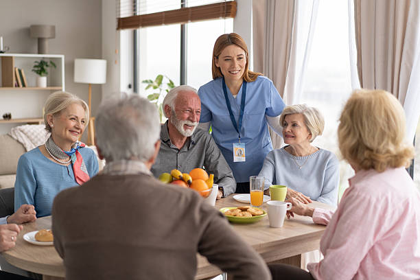 istock Friendly Caregiver Serving Breakfast to Happy Seniors Group 2237014687