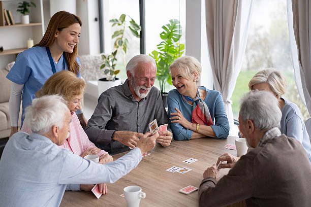 istock Nurse Assisting Seniors Playing Cards with Laughter and Joy 2237014697