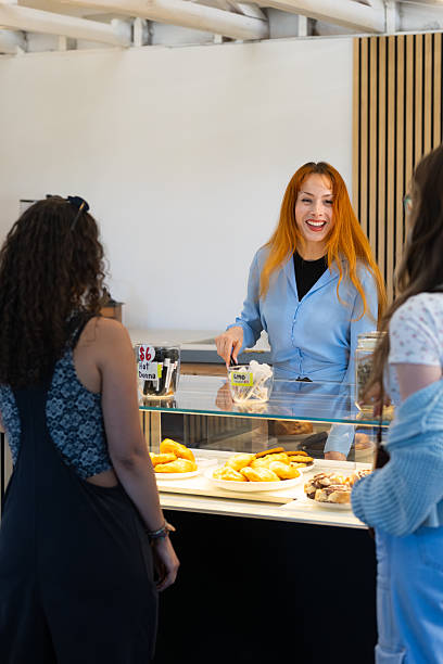 istock Cannabis Cafe Employee Smiles While Serving Baked Goods to Customers 2237015753