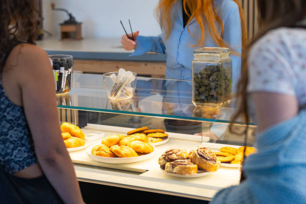 istock Employee Serves Customers Baked Goods and Marijuana From Display Case in Cannabis Cafe 2237015761