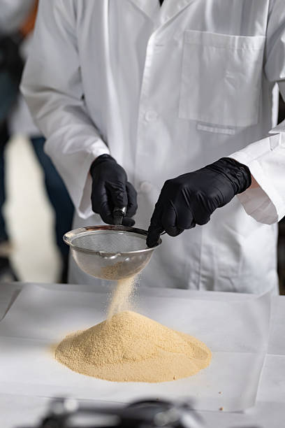 istock Employee in Cannabis Lab Filters Hash Chunks Through Fine Mesh Sieve 2237015874