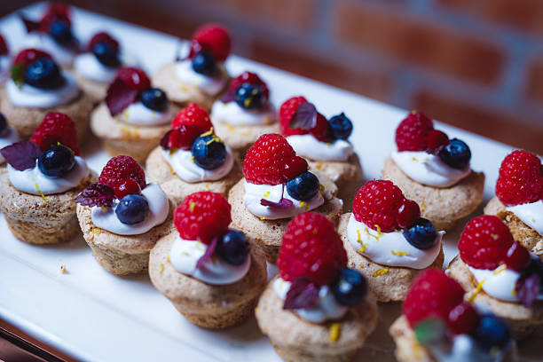 Gourmet Mini Berry Tarts with Cream on a White Platter
