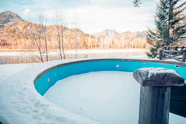 A snow-covered circular pool surrounded by mountains and trees. The scene captures a tranquil countryside vacation setting, ideal for mindfulness and relaxation.