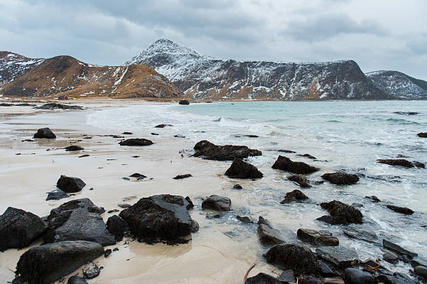 istock Rocky Beach with Snowy Mountains and Cloudy Sky 2237024663