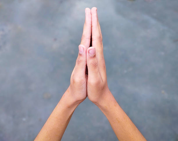 istock Hands in Namaste Gesture on the Grey Background 2237025301