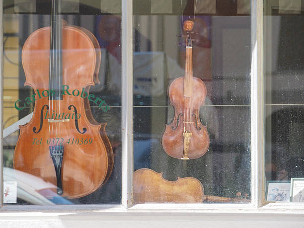 Cremona, Italy - September 3rd 2025 Charming Violin Maker Shop Window Display in Cremona Italy Showcasing Antique String Instruments in Summertime Town Center Ambiance