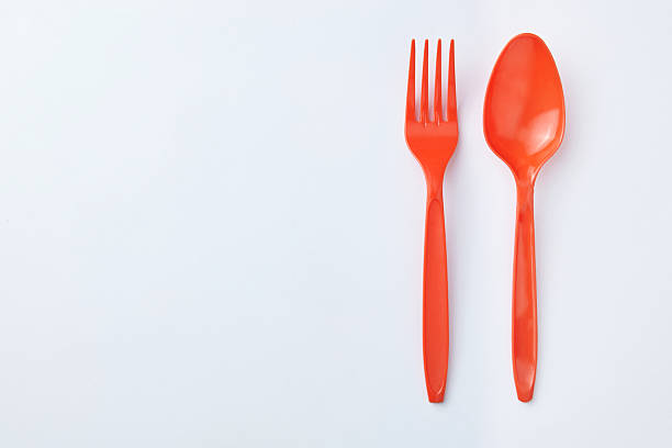 istock Red plastic spoons and forks are placed side by side on a clean white background 2237034630