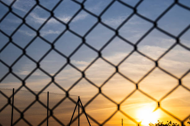 istock Sunset seen through a chain-link fence 2237037213