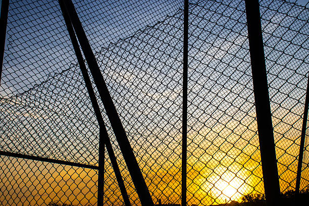 istock Sunset seen through a chain-link fence 2237037215