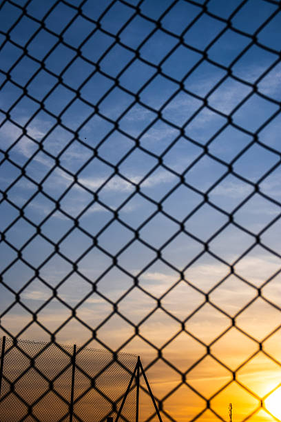istock Sunset seen through a chain-link fence 2237037220