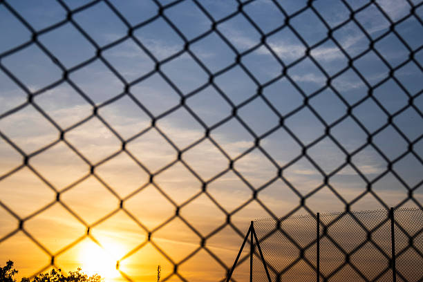 istock Sunset seen through a chain-link fence 2237037222