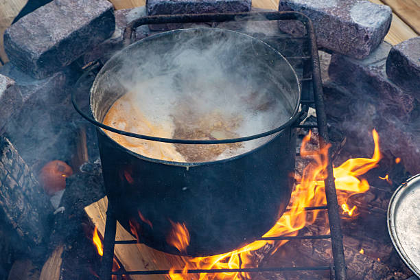 istock Cast iron pot boiling over open fire with smoke and flames 2237038400
