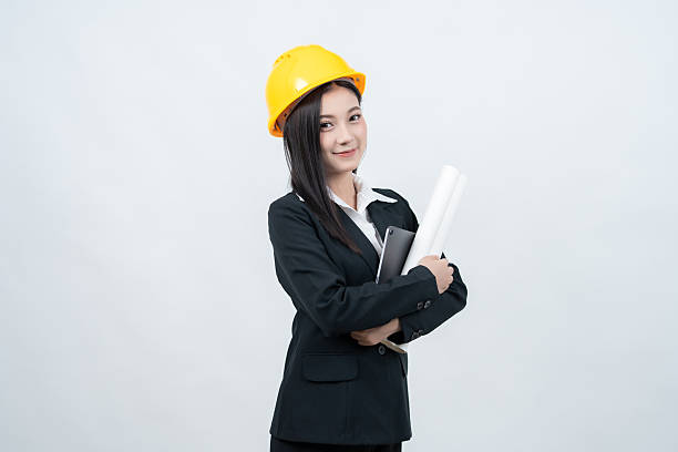 istock An Asian female engineer is photographed in a white background studio while examining a blueprint and using her laptop, embodying confidence and leadership highly valued in the industry. 2237043892