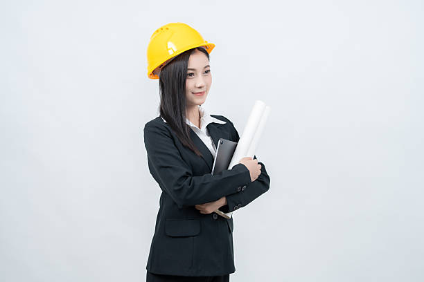 istock In a crisp white background studio, the Asian female engineer presents a blueprint with a laptop beside her, illustrating innovative solutions for challenges faced in the modern industry. 2237043896