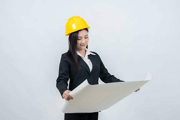 istock The image of an Asian female engineer in a white background studio with a blueprint captures the harmony of knowledge and creativity that shapes the competitive modern industry. 2237043901