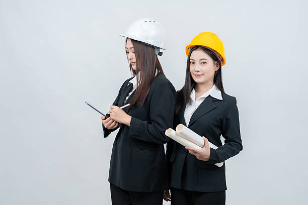 istock In a professional white background studio, an 2 Asian female engineer confidently reviews a blueprint while her laptop displays detailed data, symbolizing precision and progress in the global industry 2237043913