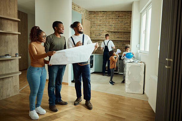 istock Happy black parents and manual worker analyzing blueprints in the apartment. 2237044968