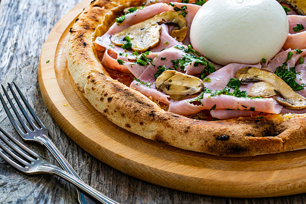 istock Circle prosciutto burrata pizza with mushrooms on cutting board 2237047916