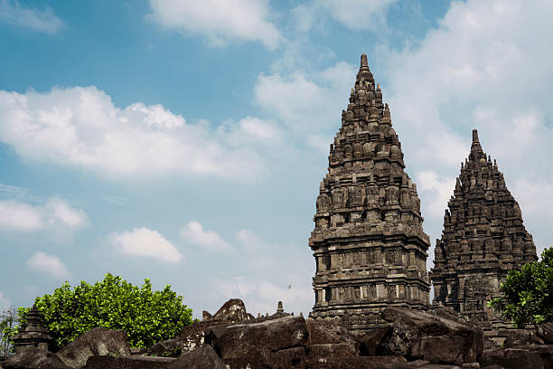 Ancient stone temples Prambanan with intricate carvings under a blue sky