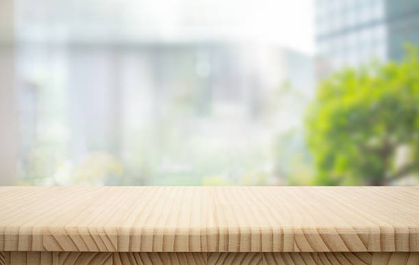 istock Selective focus.Wood table top counter with beautiful blur big glass wall texture 2237054425