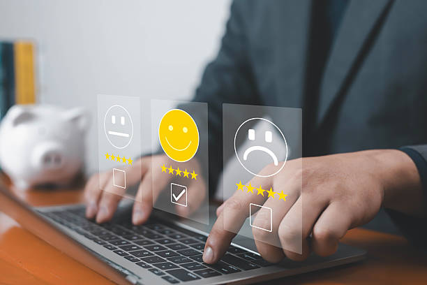 istock Businessman using laptop with virtual feedback icons showing customer satisfaction rating from happy, neutral, to unhappy faces, concept of online review, service quality, digital survey and feedback. 2237057427