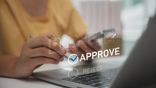 Digital document approval process with person confirming files on laptop. Concept of e-approval, online verification, business workflow, and paperless office solutions for modern organizations.