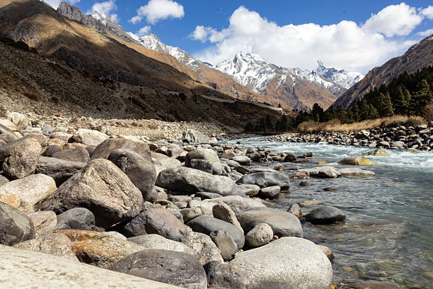 istock Mountain landscape featuring a clear river flowing through rocky terrain with snow-capped peaks and pine forests in the background, ideal for travel, adventure, environment, tourism, and nature themes 2237063339
