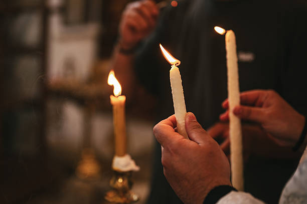 istock Unrecognizable people lighting candles in a church 2237066319