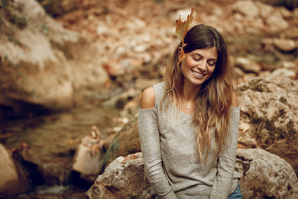 Portrait of a Nice Female with Dry Maple Leaf Behind the Ear. Happy Positive Vibes. Girl Enjoying Nature. Beauty of the Fall.