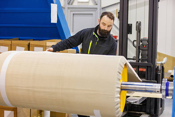 istock Bearded Worker Operating Large Paper Roll on Industrial Machine in Manufacturing Facility 2237066758