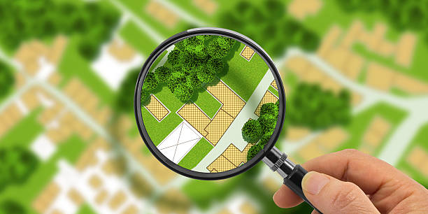 istock FIND VACANT LAND FOR BUILDING ACTIVITY AND HOME DEVELOPMENT - Concept with magnifying glass on cadastral map to find the plots of land - Building roject concept 2237070210