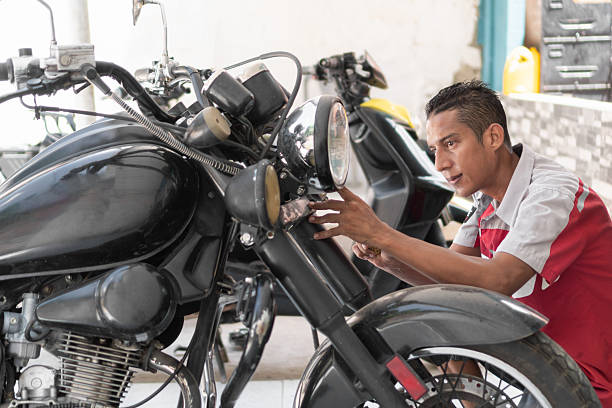 istock Mechanic working on motorcycle headlight in repair shop 2237075538