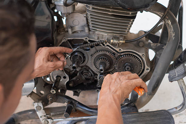 Person's hands working on the intricate internal components of a motorcycle engine