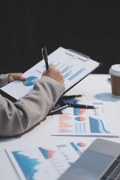 istock Business woman using calculator and writing make note with calculate. Woman working at office with laptop and documents on his desk 2237083006
