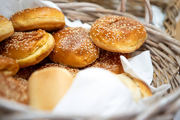 many baked sesame topping burger breads lay on oven tray waiting for cooking, shot with shallow focusing and tilted lens effect for background wallpaper
